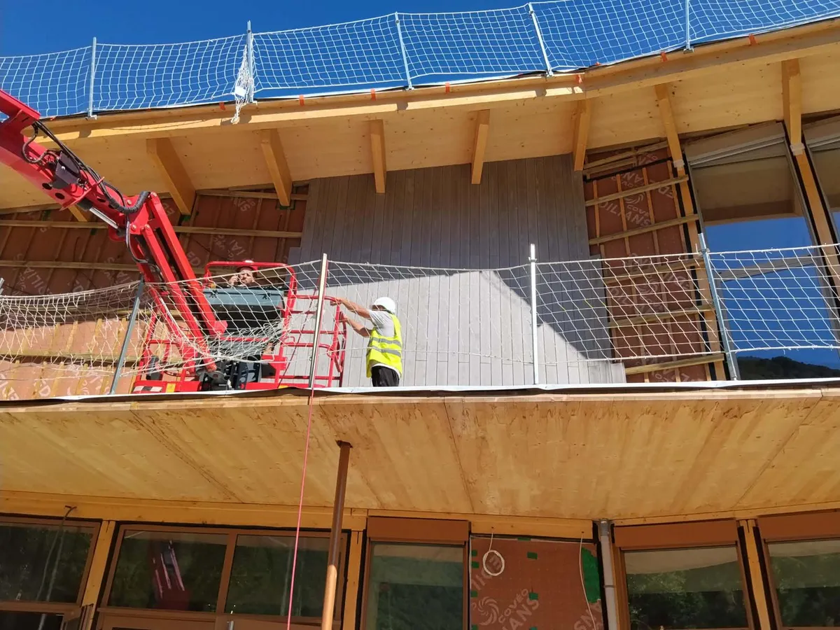 Pose de bardage bois en façade depuis une nacelle