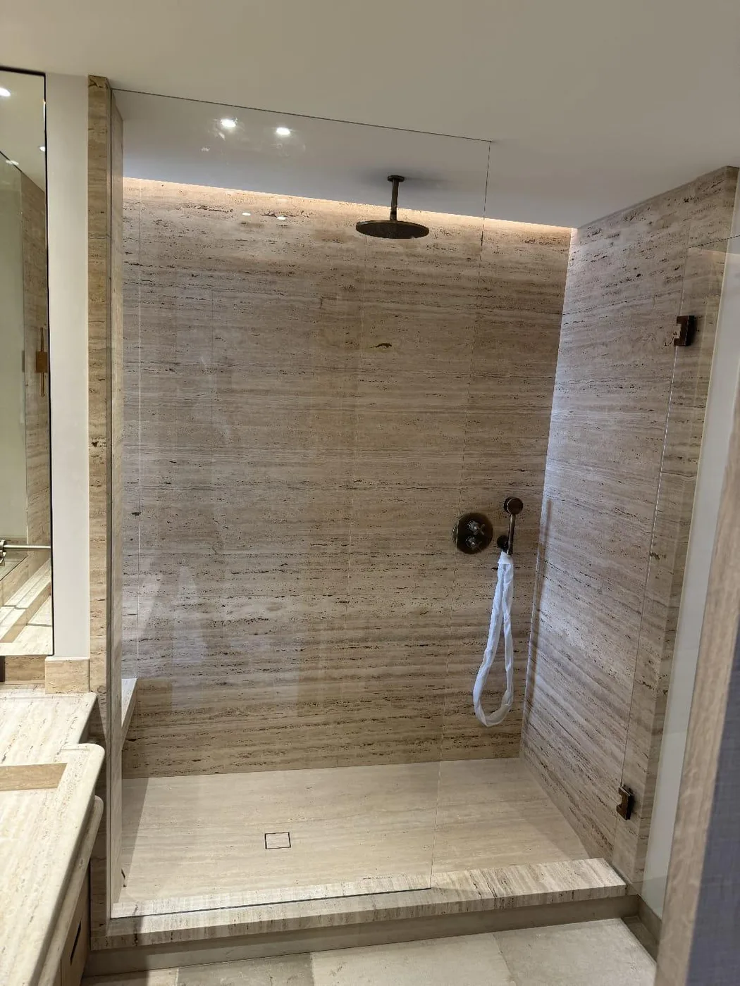 Salle de bain en travertin avec douche à l'italienne
