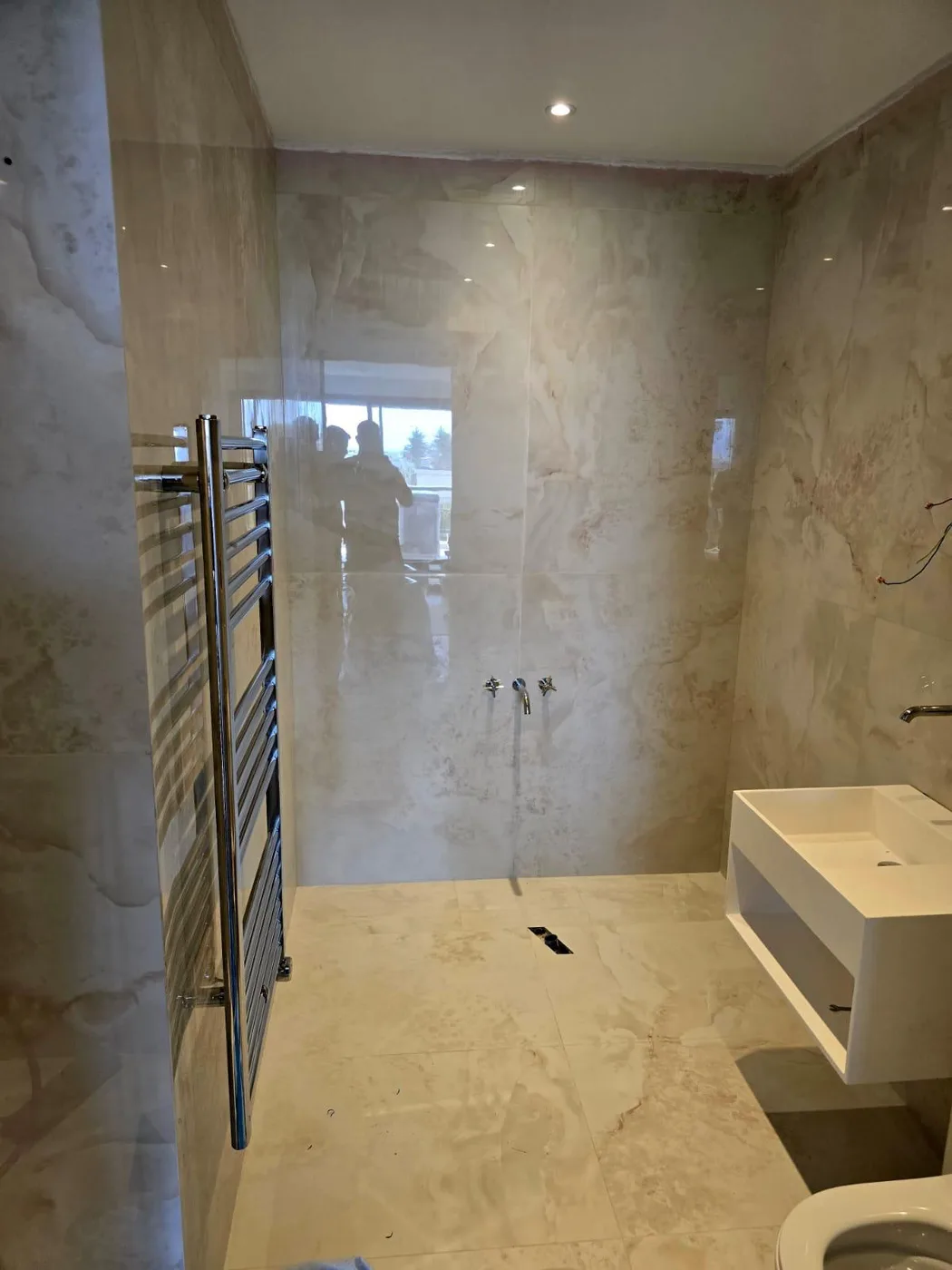 Salle de bain en marbre avec douche et sèche-serviettes